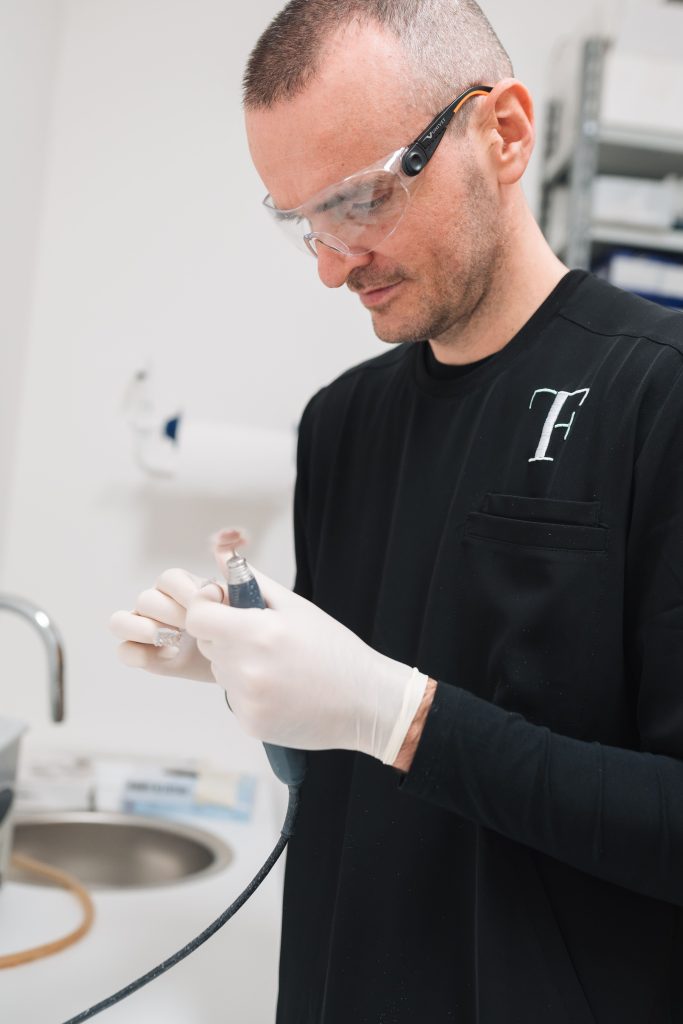 Dentista al lavoro nello studio Frangini-Teglia. Cura dentale professionale e attenzione al dettaglio per un sorriso sano.